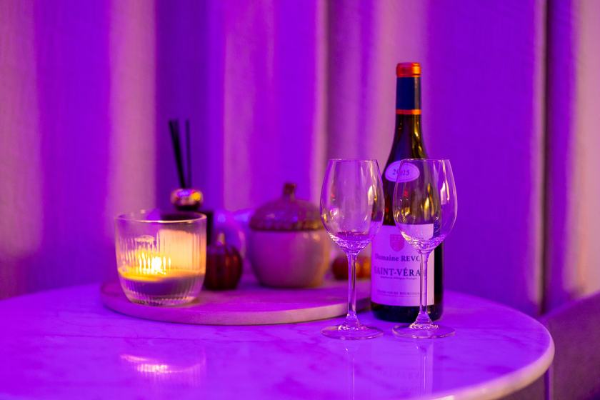 Spa Signature : bouteille de vin, verres et bougie sur la table en marbre