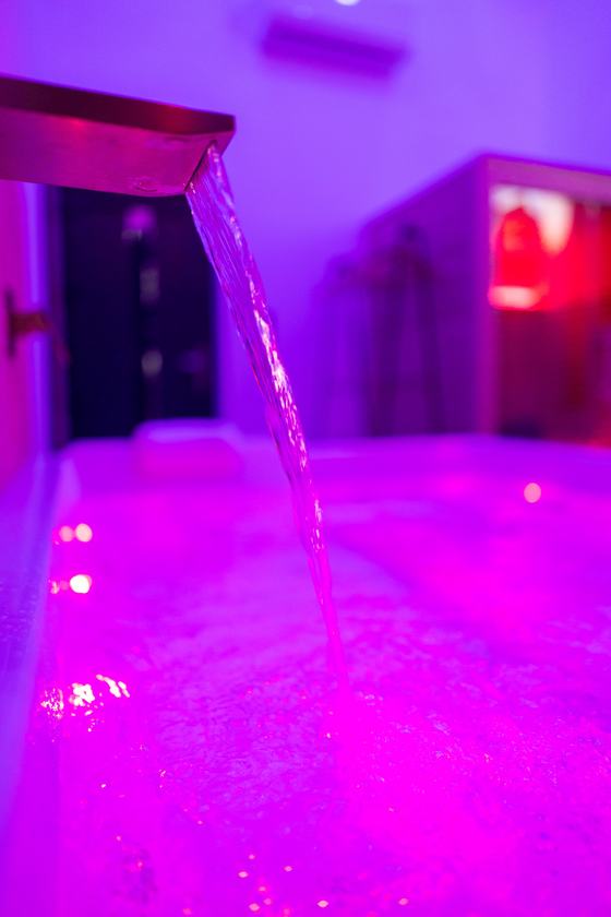 Spa Signature : cascade du jacuzzi, sauna en arrière-plan